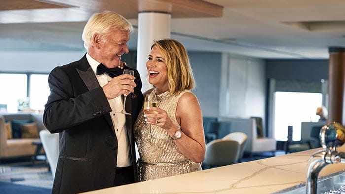 A couple enjoying drinks at the bar in the Britannia Lounge on Spirit of Discovery